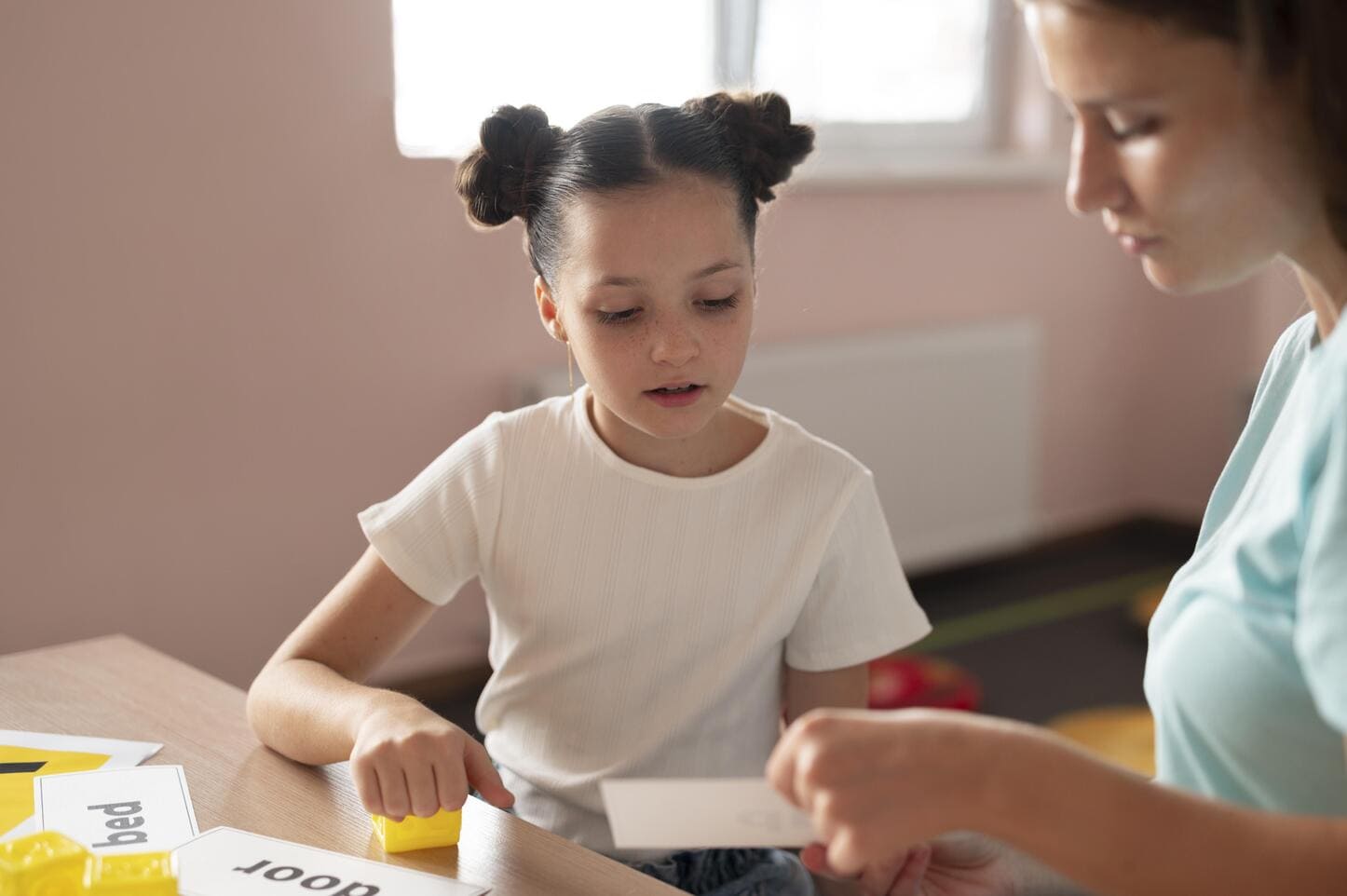 Logopeda trabajando el lenguaje con una niña en sesión de logopedia